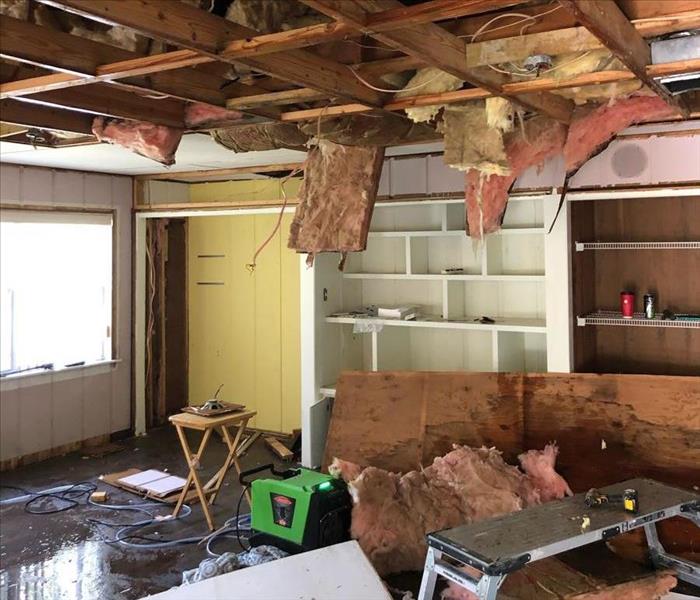 ceiling falling down in den with insulation hanging down and standing water on floor