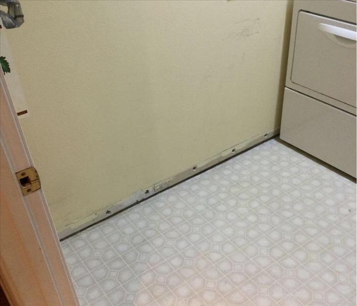 laundry room with baseboard removed and holes at baseboard height