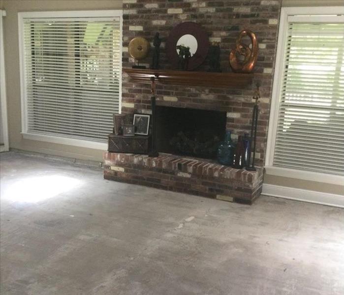 living room with brick fireplace and concrete subfloor exposed