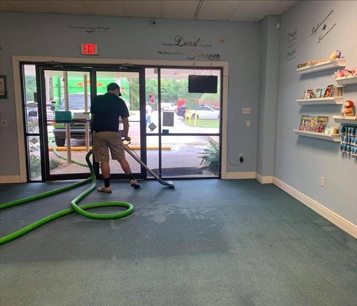 man extracting water from carpet in commercial property retail showroom 